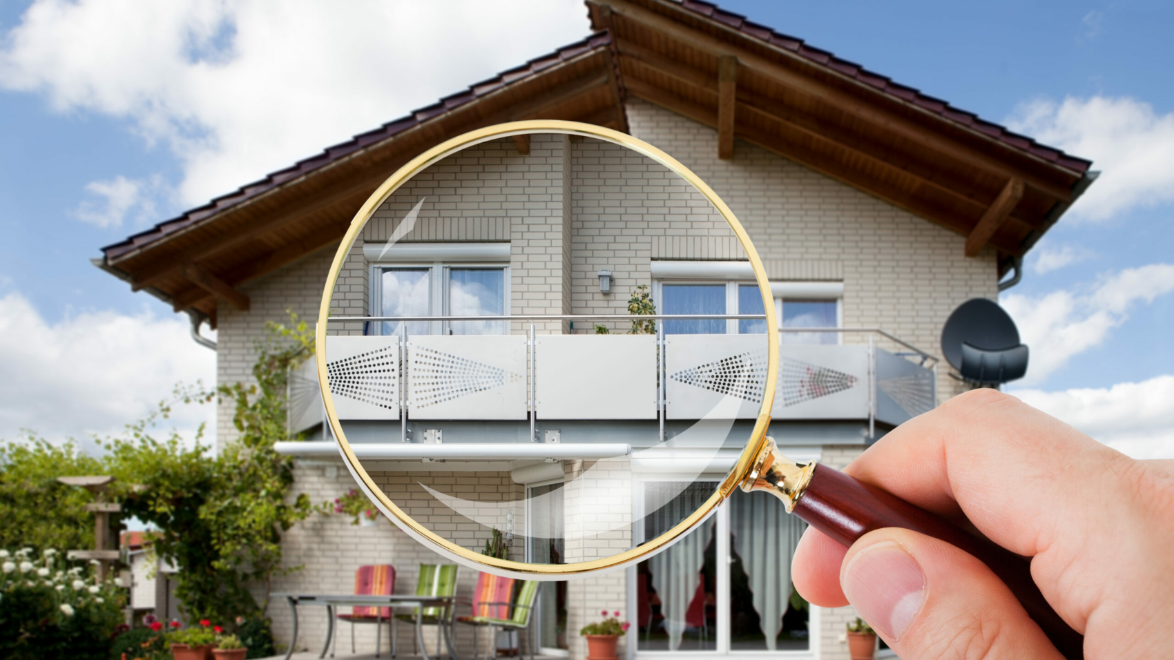 Person,Hand,With,Magnifying,Glass,Over,Luxury,House